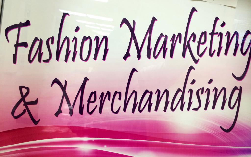 A banner advertising the Fashion Merchandising class hangs in a display case next to the library.