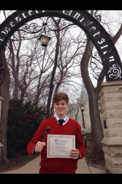Photo Taken by Mr. Thompson. Gordon Schlicht holds his best delegate award in front of the gates of Northwestern University.