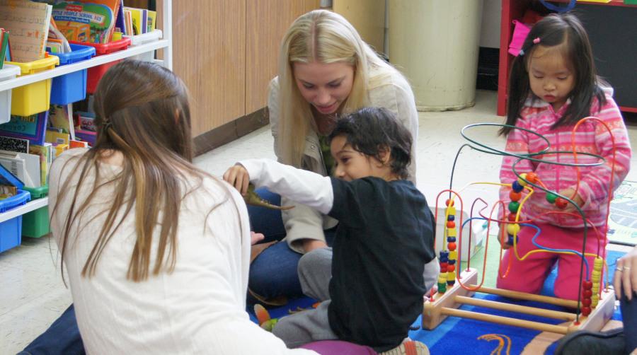 Students at LHS teach and play with toddlers. Pictured here, high school students and preschoolers begin the class with free play. 