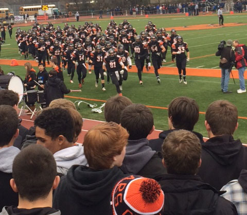 The Cats Varsity football team runs to the student section before their semifinal game against Cary Grove this past Saturday.