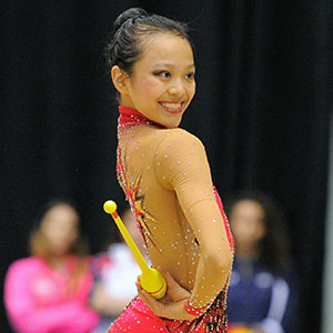 Freshman Laura Zeng flashes a smile at the judges during her rhythmic gymnastics routine. Photo courtesy of USA Gym.