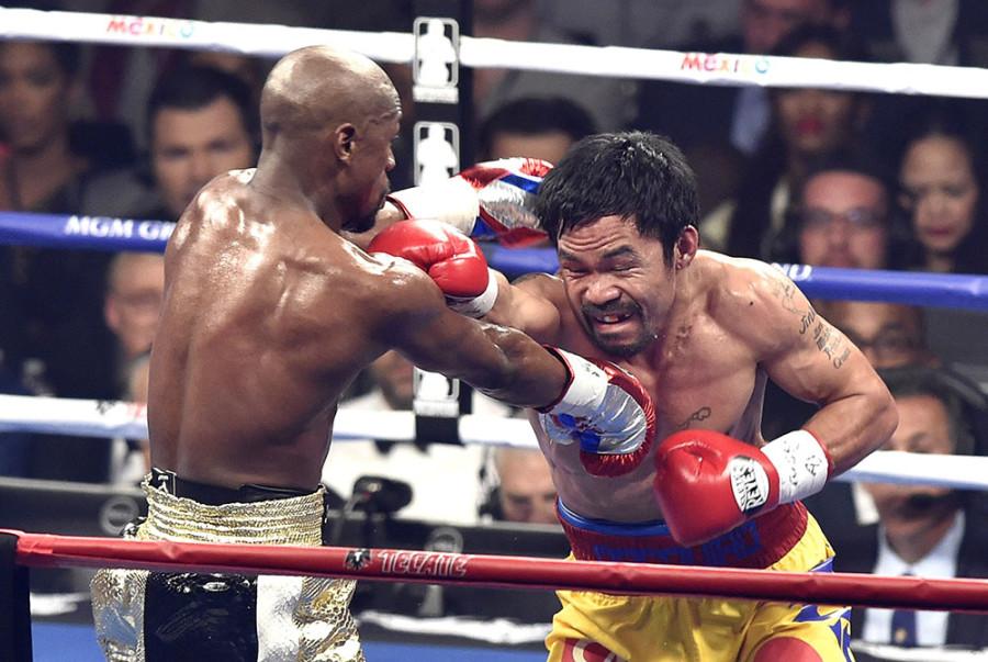 Floyd Mayweather Jr., left, lands a punch on Manny Pacquiao in the fourth round of the WBC Welterweight Championship at the MGM Grand Garden Arena in Las Vegas on Saturday, May 2, 2015. Mayweather won in a unanimous decision. 