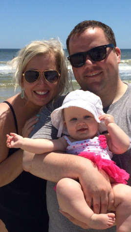 Henneberry (right) carries his daughter, Harper, in his arms with wife, Lindsay, by his side.