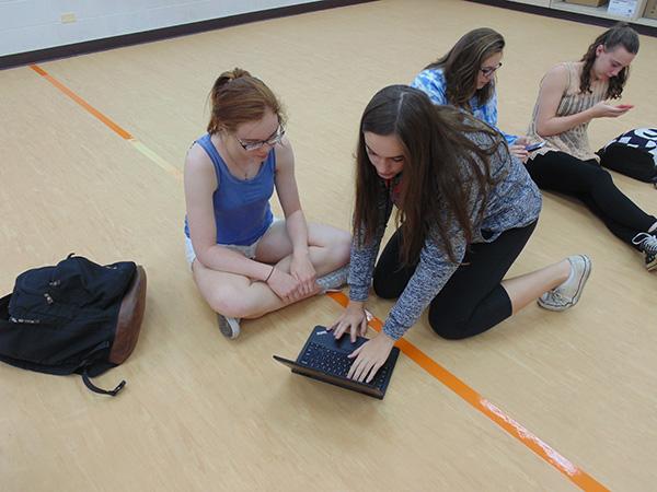 Junior Beth Vogg aids freshman Annalisa Waddick with her powerschool login.