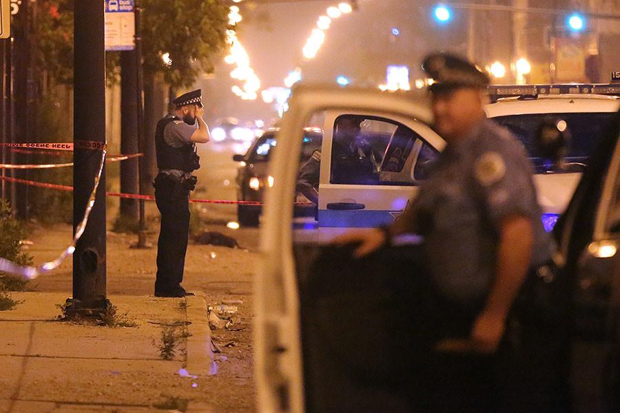 A police officer rests his hand on his forehead at the scene where a 23-year old man was shot in the face in the early morning hours Monday, July 6, 2015 near the intersection of West Ferdinand Street and North Cicero Avenue in the Austin neighborhood of Chicago. (Anthony Souffle/Chicago Tribune/TNS)