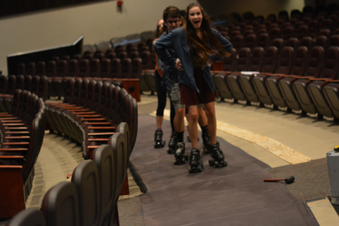 Seen above, set construction for the musical took out rows of seats in the auditorium to allow cast members to skate through the audience during the show. Hannah Hartung (in front) leads others as they practice on ramps.