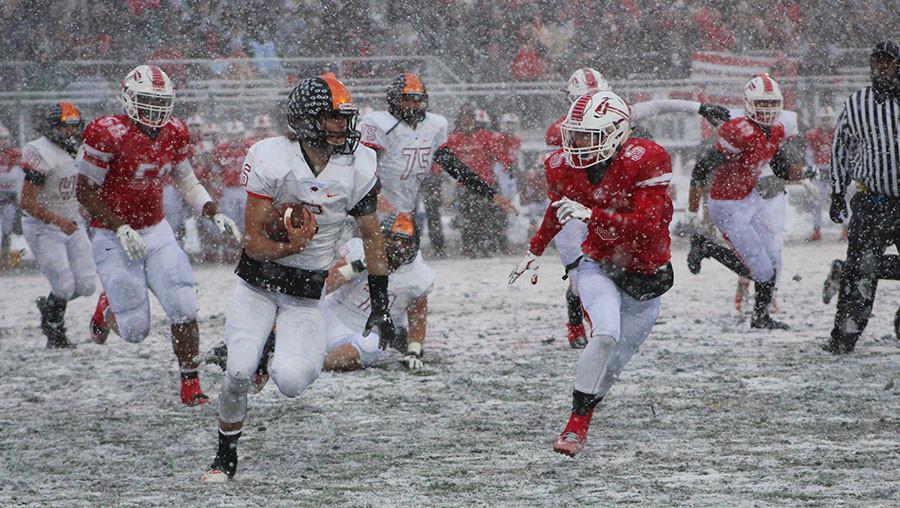 Quarterback Riley Lees (#6) runs around the edge in the semi-final game against Bradley-Bourbonnais in a blizzard.