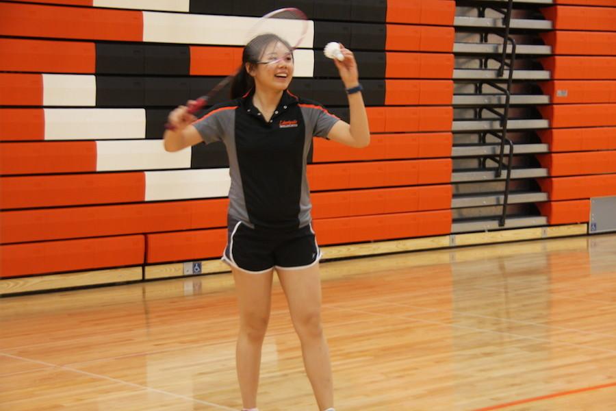 Getting ready to serve, Liu gets into position before she strikes the birdie