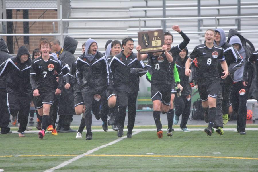 The team celebrates its sectional title Saturday in the pouring rain.