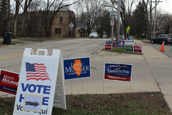 Campaign signs rest outside a local polling place, where voters are welcome to participate in the March 15 primary.