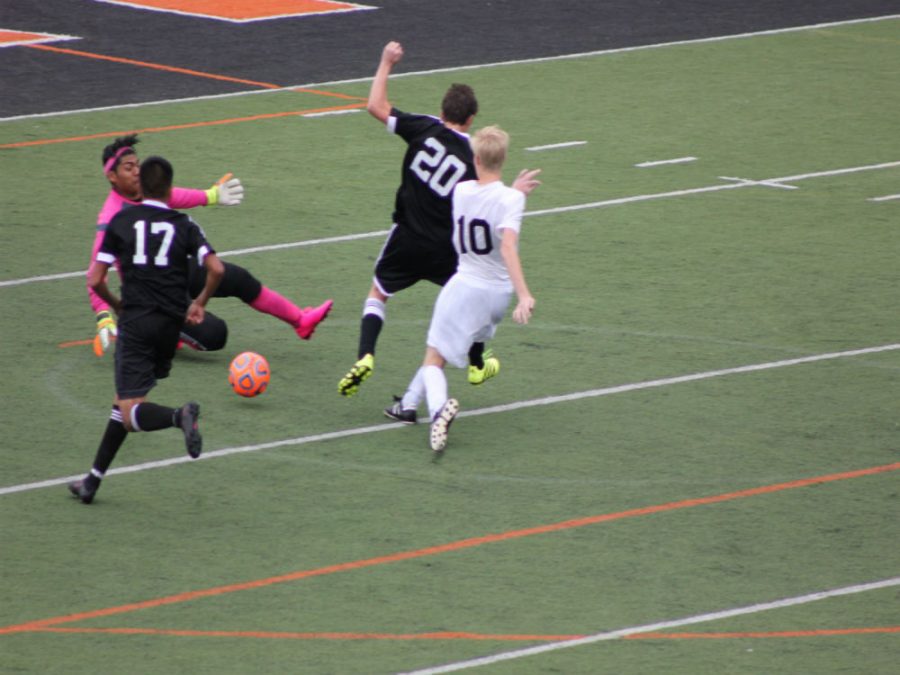 Senior Ryan Bogan kicks the ball past two thunderbolt defenders.