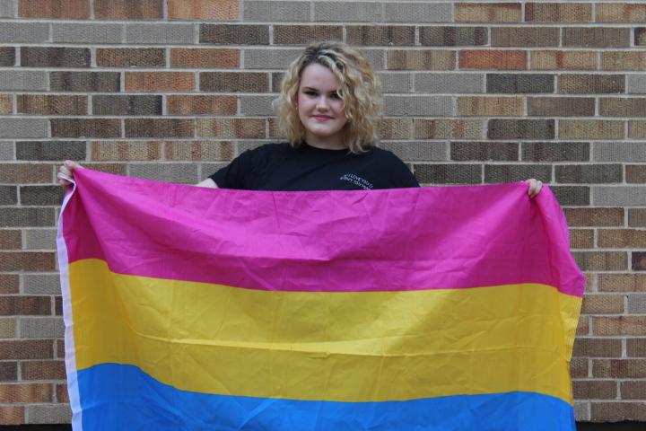 Anna Legutki, president of the LHS Gay Straight Alliance, holds up the pan flag to show pride in her sexuality. 