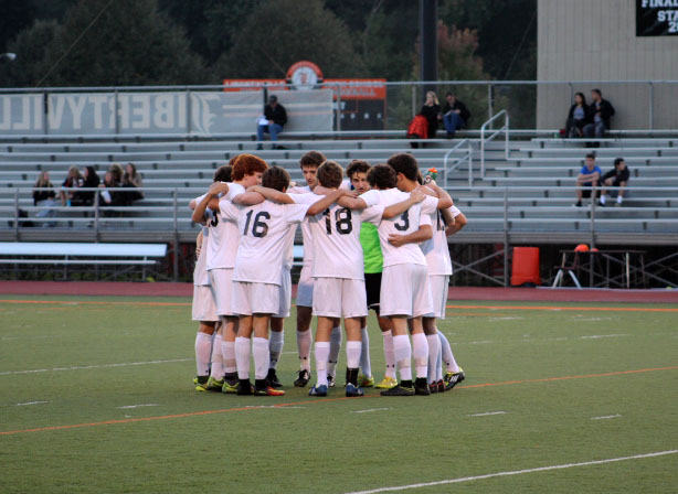 The starting lineup of the Libertyville High School boys varsity soccer team huddles on the field before the start of the game.