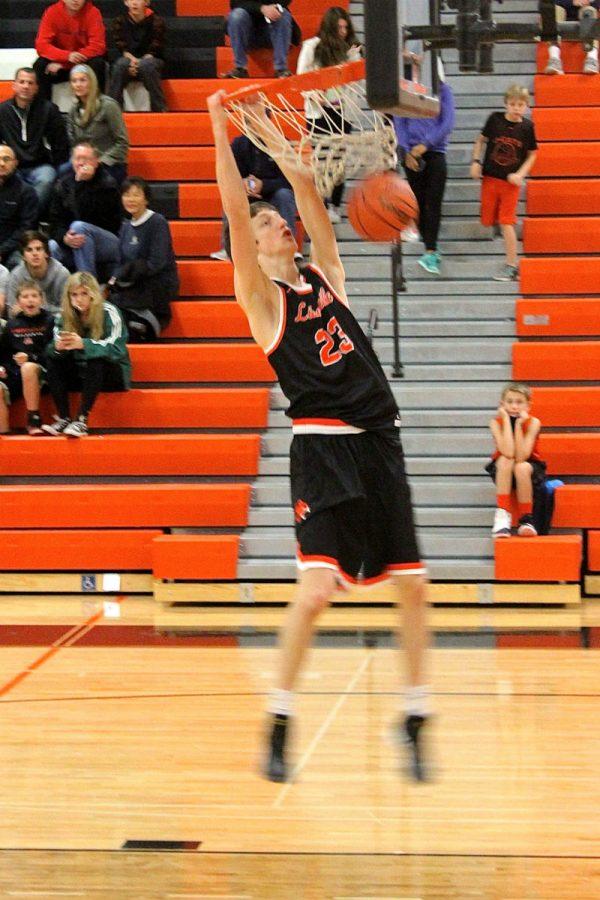 Junior small forward Drew Peterson dunks the ball after a steal, leading to a fast break.
