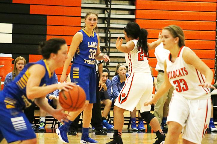 Junior Zi Tompkins (24) defends Lake Forest forward Maeve Summerville as Morgan Manski (33) defends Delaney Williams.