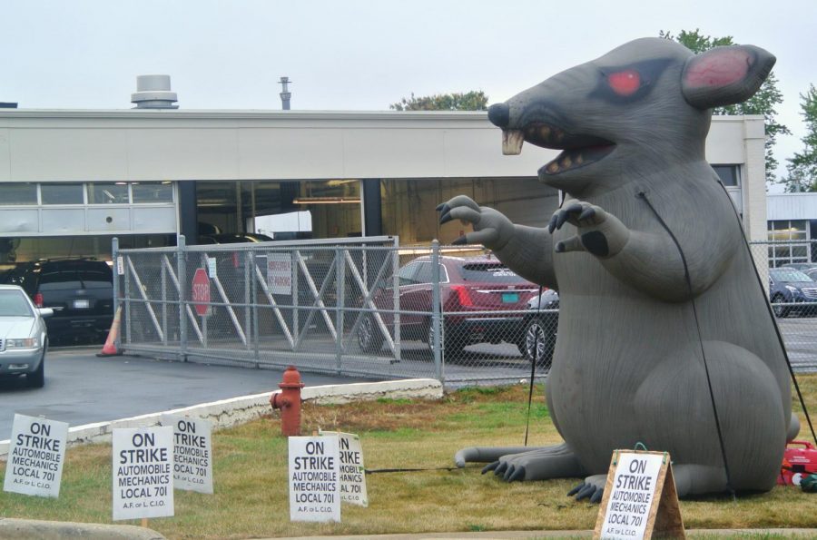 When striking outside of the Napleton Cadillac Dealership, the mechanics have a display set up, which includes picket signs in front of the dealership (not pictured) and on the right side of the dealership and a an inflatable rat lawn ornament. 