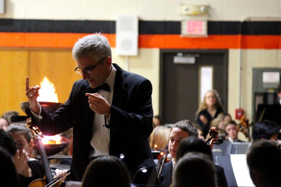 Mr. Jeremy Marino conducts the concert orchestra in their spooky rendition of “Feel It Still.”