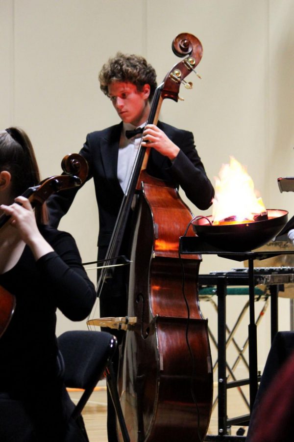 Bass player Nate Rezell plays “Funeral March of a Marionette” next to a spooky cauldron with the chamber orchestra.