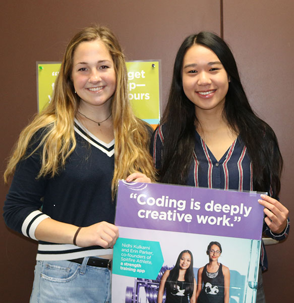 Graton (left) and Tong (right)  holding one of the many posters hung around the computer science classroom.