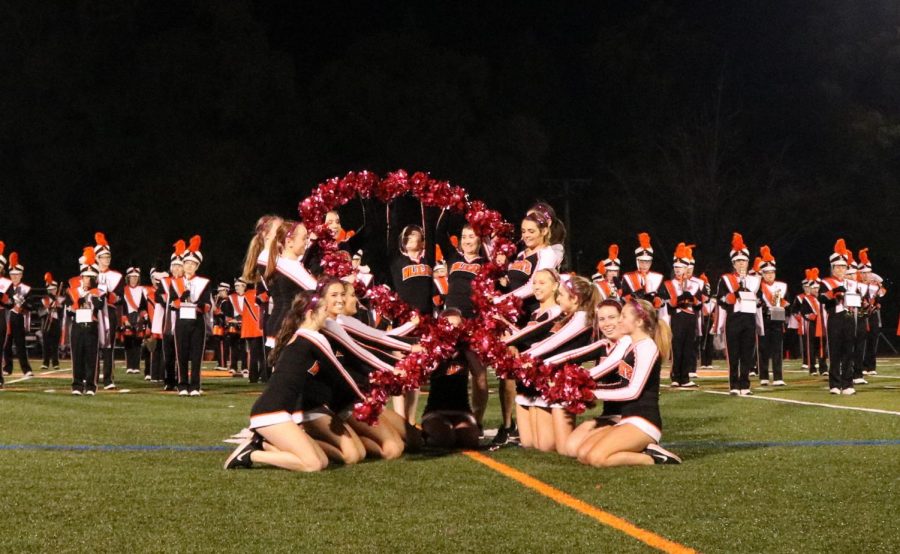 The varsity poms team shows off their breast cancer awareness during the halftime performance by using pink pompoms and placing them in the shape of a pink Breast Cancer Awareness ribbon. 

