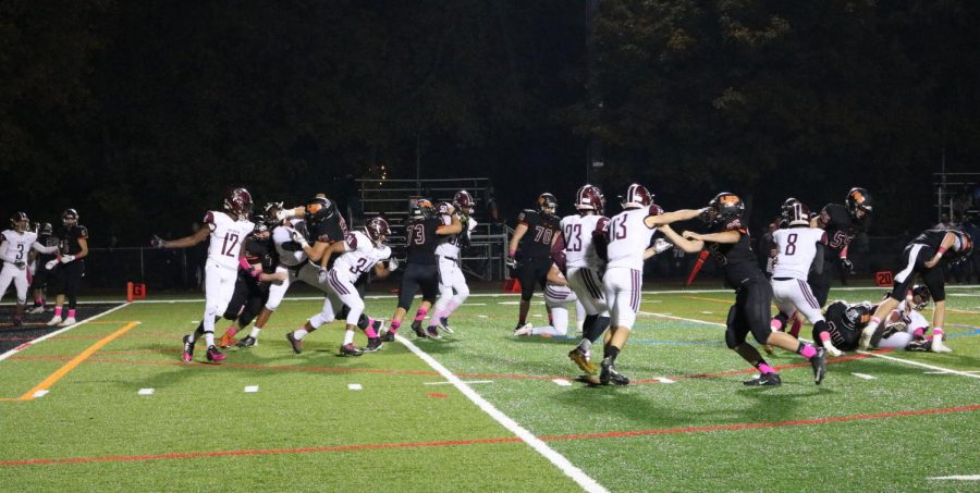 The offensive linemen try to clear a path for running back Ben Arnold to plow through the Zion Benton defense as Libertyville drives toward the end zone.