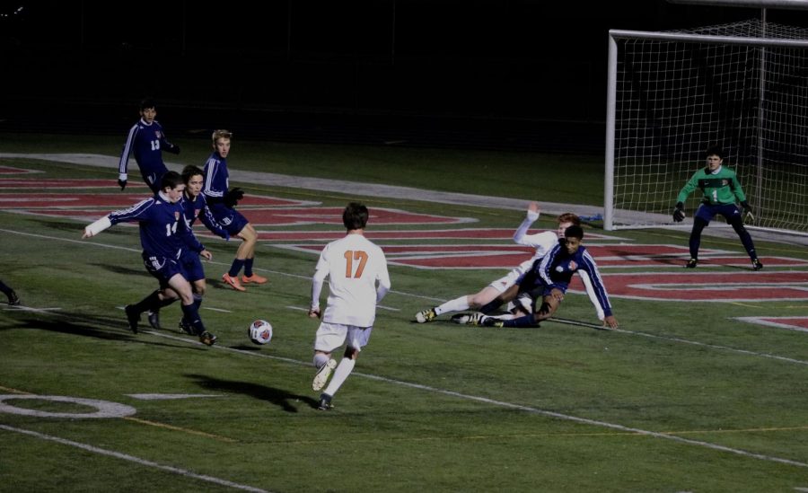 Tanner Kelly (17), a junior, rushes to the ball after junior Evan Rasmussen was slide tackled.