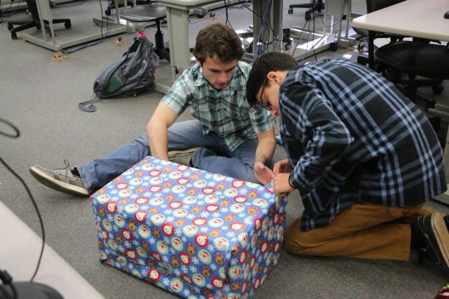 Students of Dr. Kellum's WISH class, Daniel Ritz and Gregory Yonan, wrap a present they bought for their WISH family.
