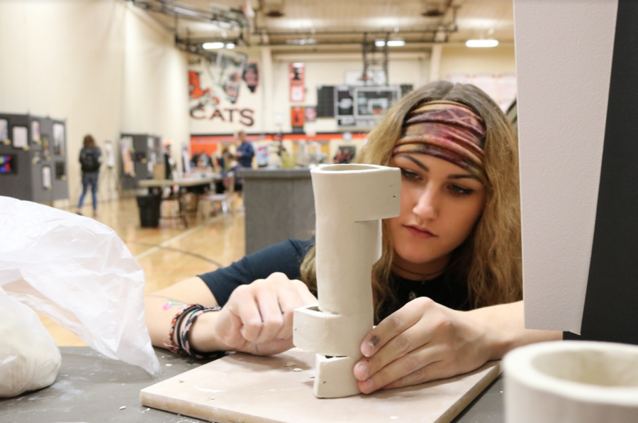 Junior Hannah Hartshorn works on a 3D piece for her concentration at the art show.