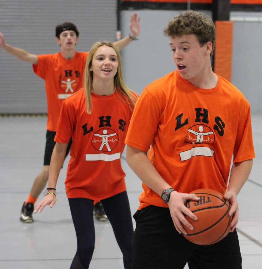 Freshmen Joey Neal, Claire Arnold and Dillion McDonald are just some of the freshmen participating in the basketball gym unit in Ms. Patti Mascias third-period freshmen P.E. class