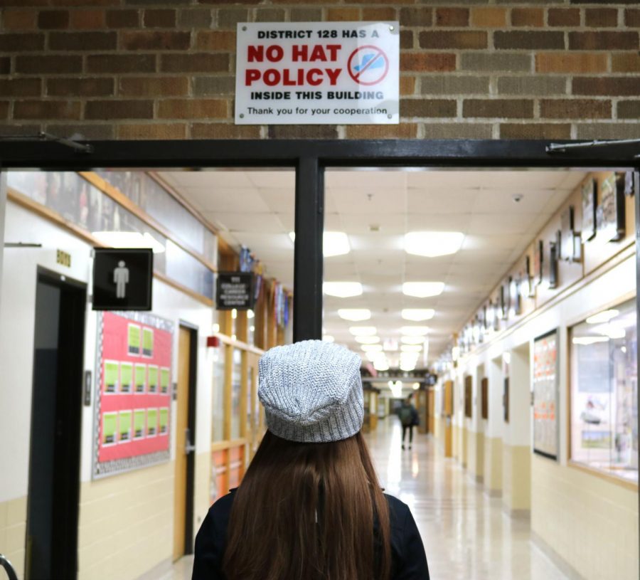 Despite signs around the school and current school policy, senior Megan Wolter and other students are still able to wear hats to school and in the hallways without getting in trouble.