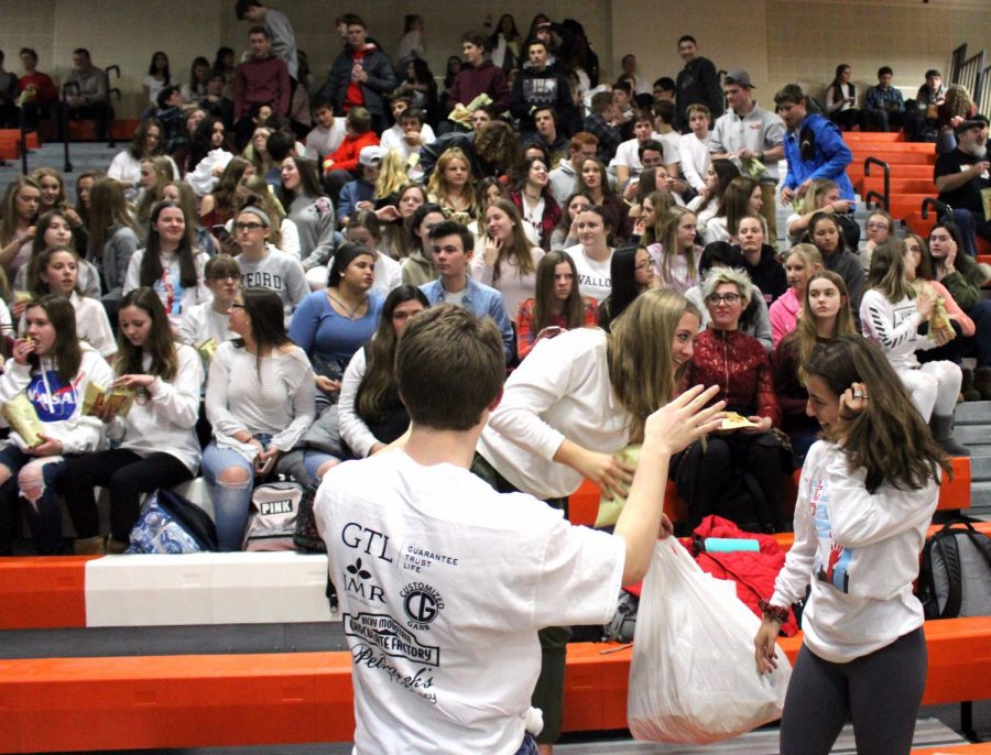 Sophomore spirit leaders distribute popcorn to the stands as part of the “On Demand” experience.