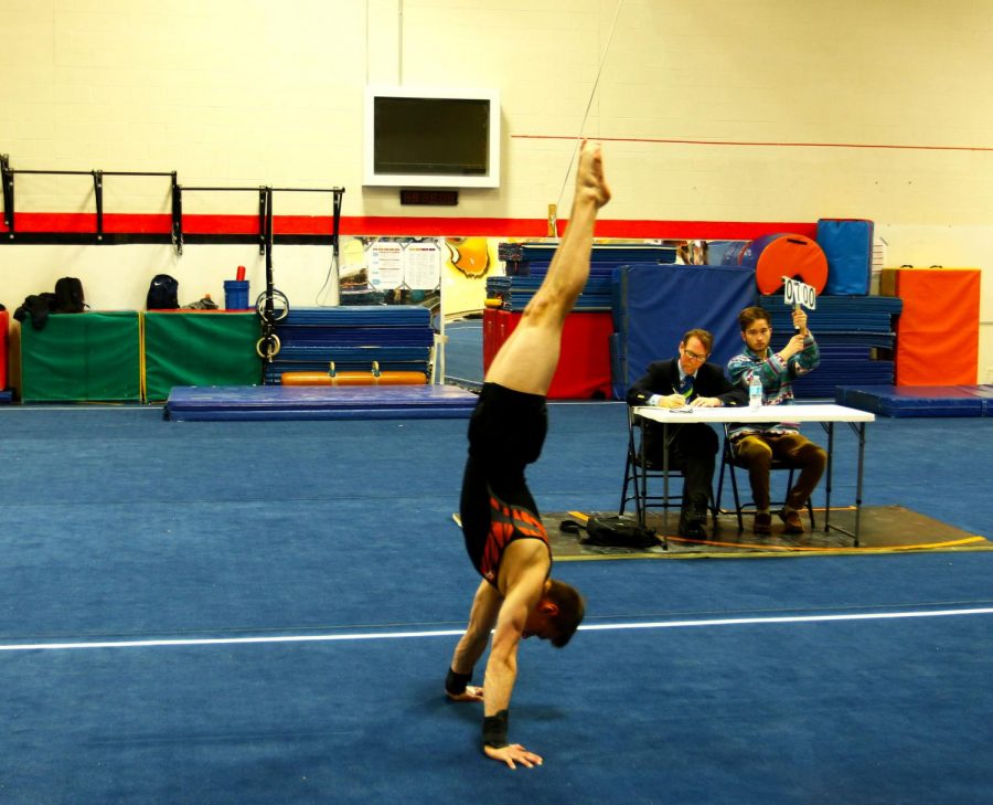 Tyler Kukla performs a handstand during his floor exercise routine. Kukla won first on floor and second on rings for the night. 