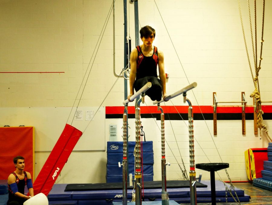 During another performance on the parallel bars, senior Alex Ferreira holds an L-Sit. 