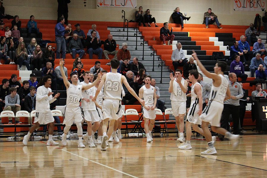 Drew Peterson celebrates with his teammates, who are ecstatic after a huge 3-point shot, during their home game against conference opponent Lake Zurich.