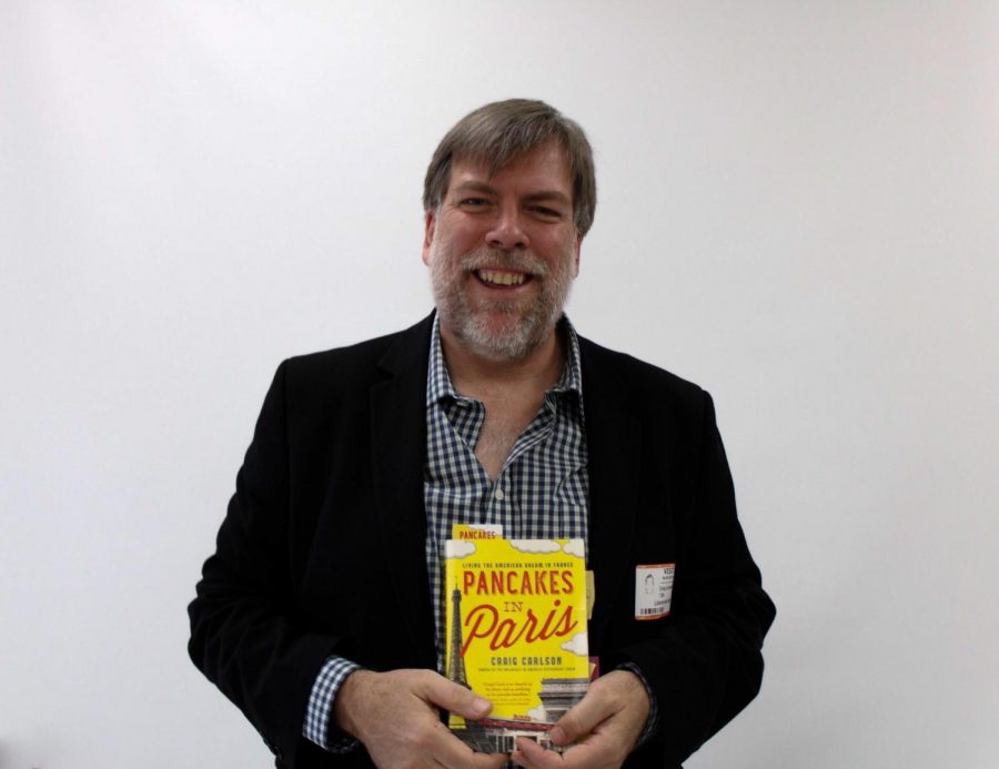 Craig Carlson poses with his book, Breakfast in America, which details the story of how Mr. Carlson came to open his own restaurant in Paris.