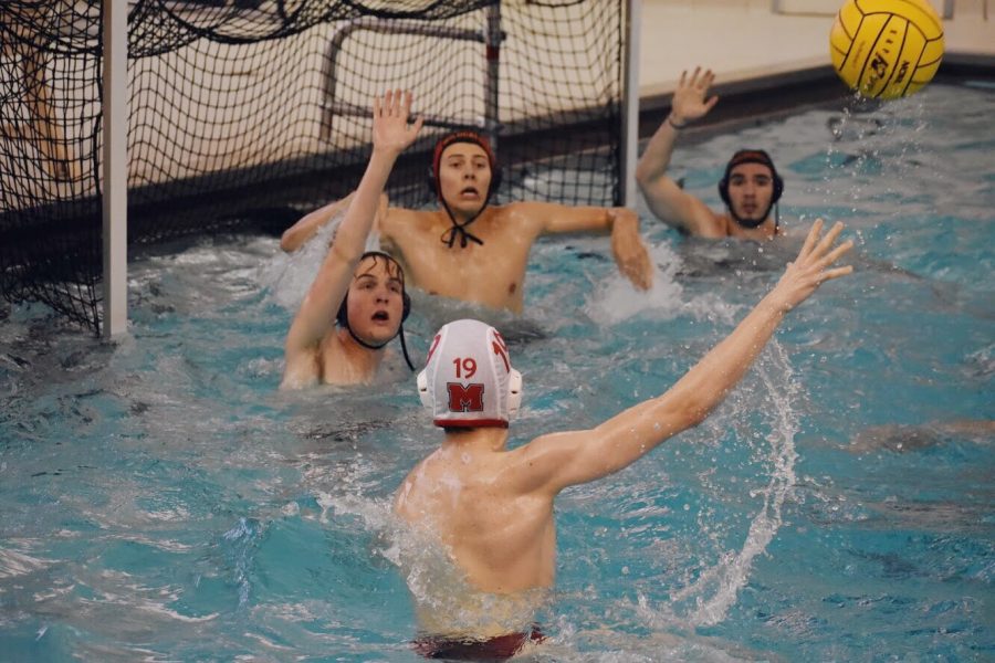 Seniors Max Kratcoski, goalie Jack Otto and Nick Harrington reach to block an attempted goal from an opponent.