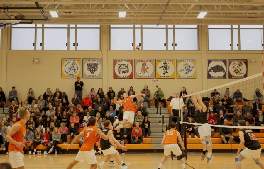 Senior Brendan Cook (23) jumps up for a spike at the end of the first set in which Libertyville won 25-23