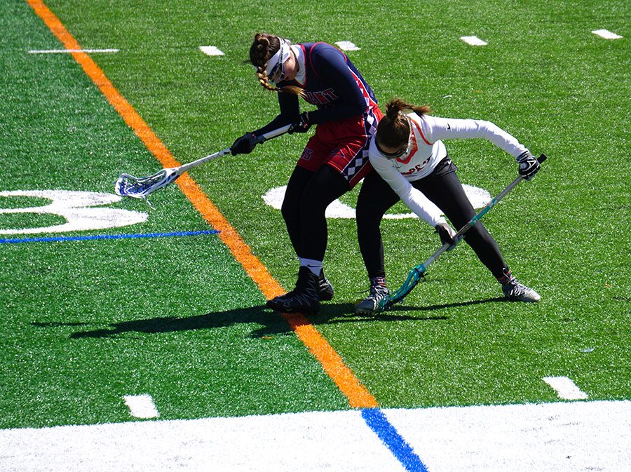 Junior Maggie Burnetti (who is the Sports Editor for Drops of Ink) fights a Conant player for a ground ball.