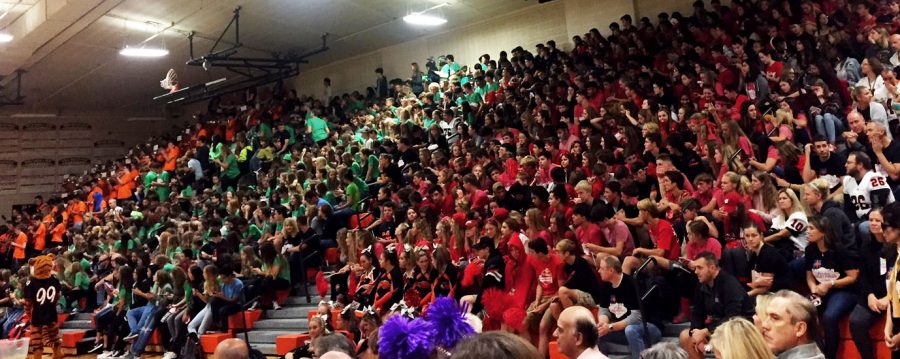 The freshman, in green, and the sophomores, in red, wait for the assembly to start. The band -- far left, in orange -- performs while students arrive.