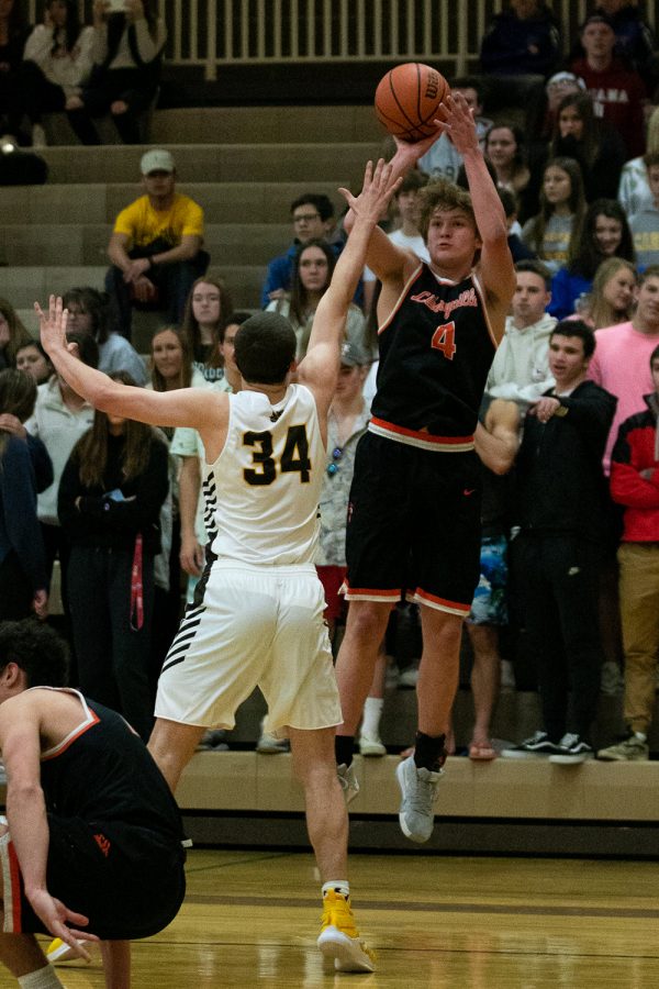 Pulling up from distance, junior Will Moore shoots a three-pointer.