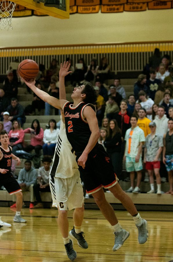 Senior Brian Wilterdink reaches back towards the basket to add two points for the Cats.