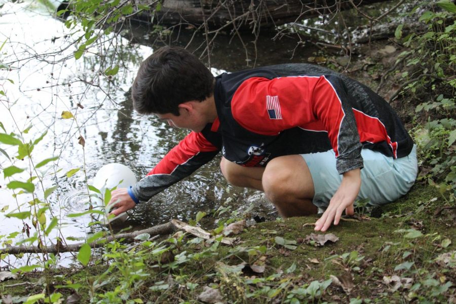 Matt Engfer, a senior in Mrs. Jennifer Kahn’s AP Environmental Science class, is taking samples of Butler Lake for their experiment to measure the acidity and conductivity of water.