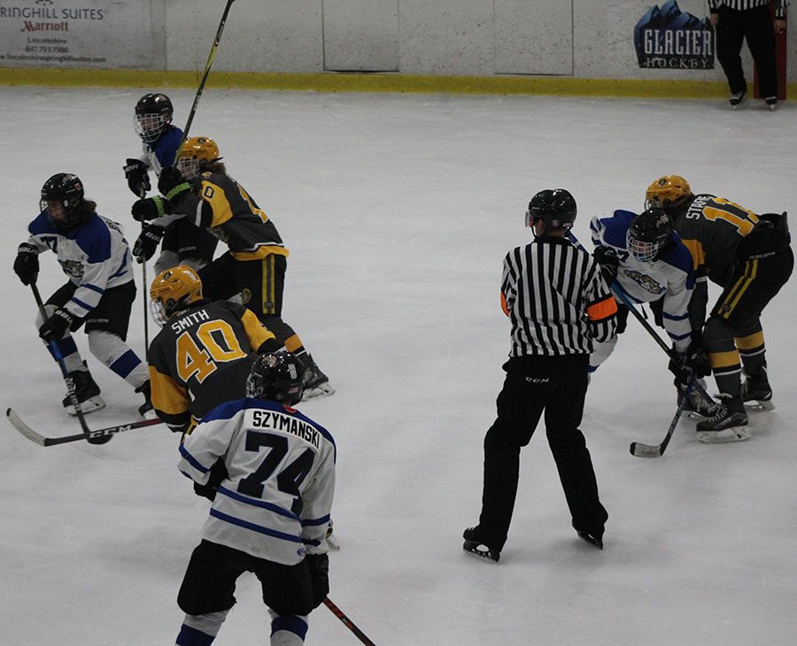 Looking for the puck after a face off, Junior Ayden Szymanski heads towards the puck.