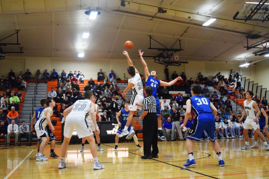 Both teams’ eyes follow the ball as Clark (32) and Nick Marcinkiewicz (44) jump for the ball in the tip-off. Clark is able to swat the ball towards his teammate to start the game on offense.