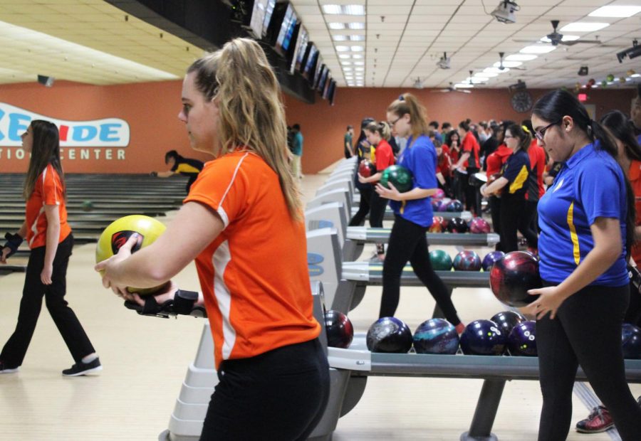 Alongside players from Warren Township High School, senior and Drops of Ink staff member Katie Felsl prepares to bowl during the routine 10 minutes of practice before the start of the match.