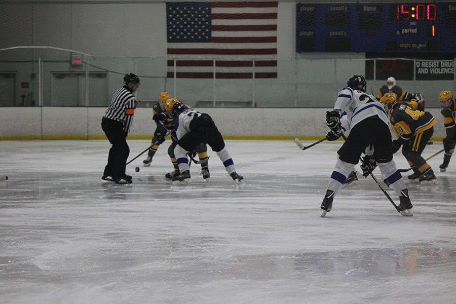 LHS Senior Kyle Junkunc wins the first puck drop of game for the Cats.