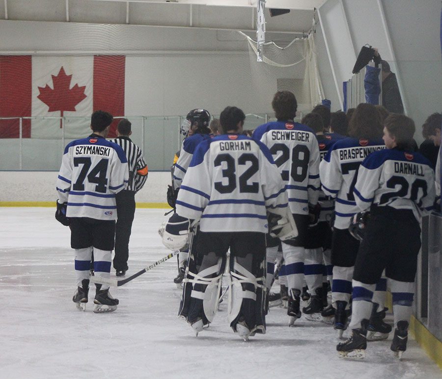 The team lines up along the bench for the National Anthem.
