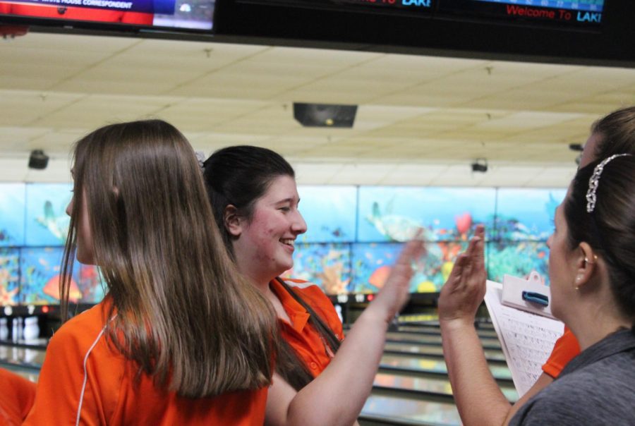 Junior Sarah Kenzer celebrates and gives high-fives after her turn. After almost every strike, the team would recite a chant to cheer on the teammate.