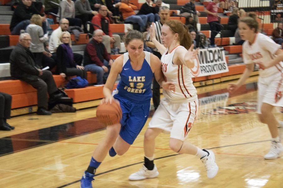 Finola Summerville (13) drives to the basket while Lydia Crow (50) plays tight defense on her.