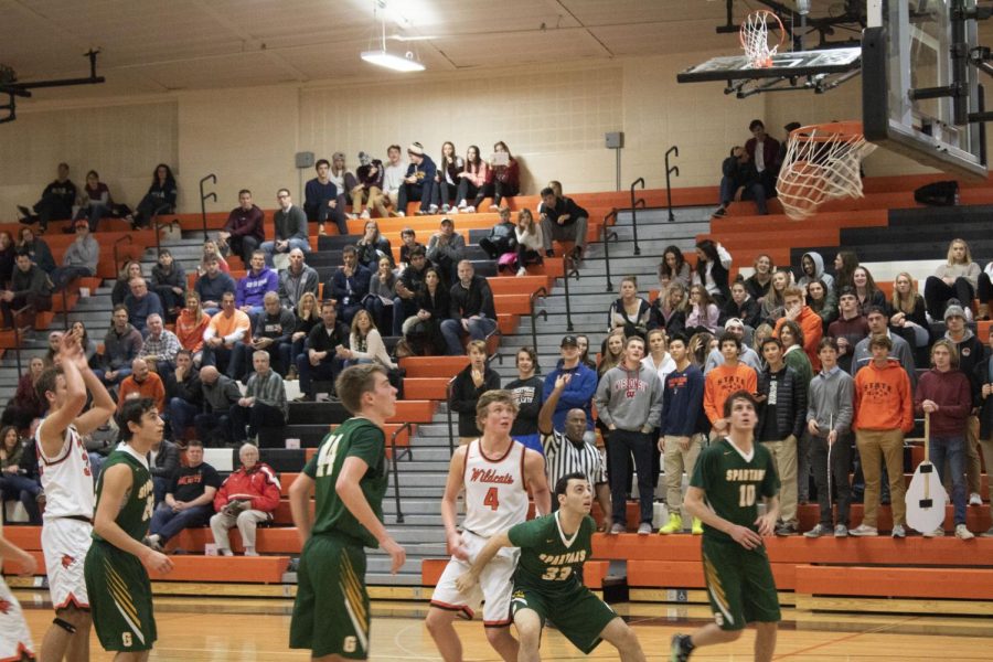 Senior Travis Clark makes his second free-throw attempt as players from both sides look on.